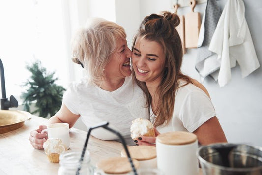 Happy mom and daughter sharing cupcakes in kitchen—perfect Mother's Day moment for sporty moms, featuring Volleybird