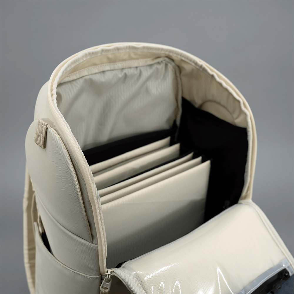 Beige backpack with compartments on a gray background