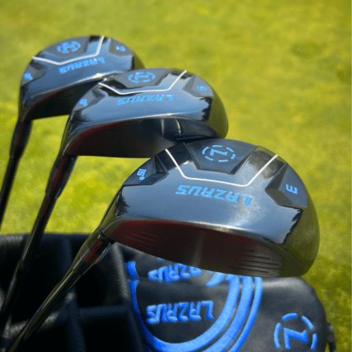 Close-up of golf club heads with 'Lazarus' branding on a grass background