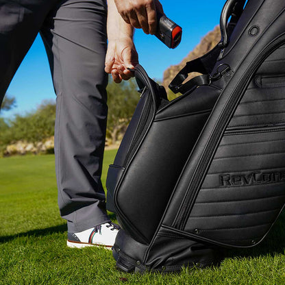 Person opening a golf bag with a club on a golf course