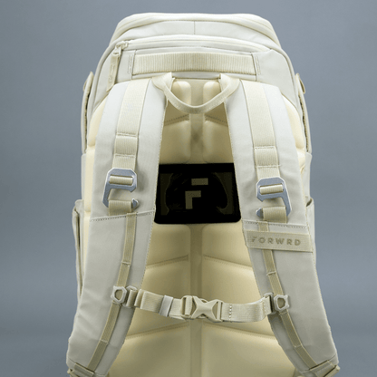 Beige backpack with multiple straps and a visible brand logo on a gray background