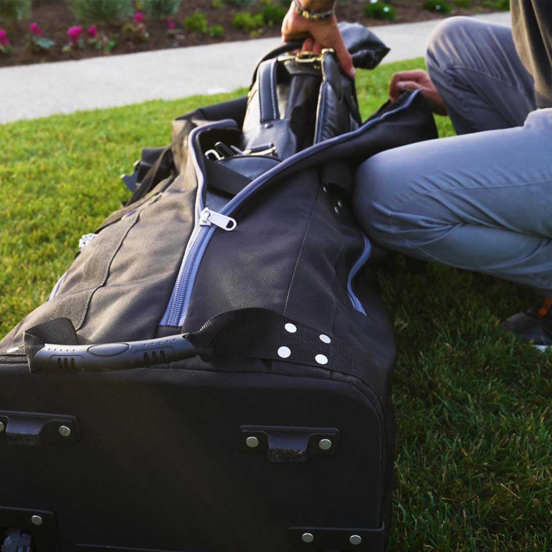 Person packing a suitcase on grass