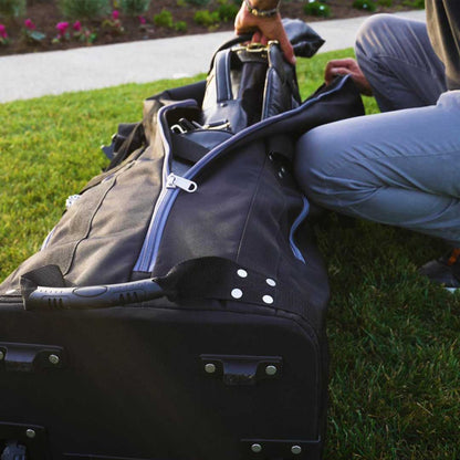 Person packing a suitcase on grass