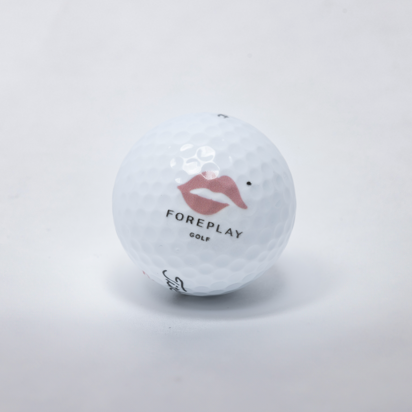 Golf ball with 'Foreplay Golf' logo on a white background