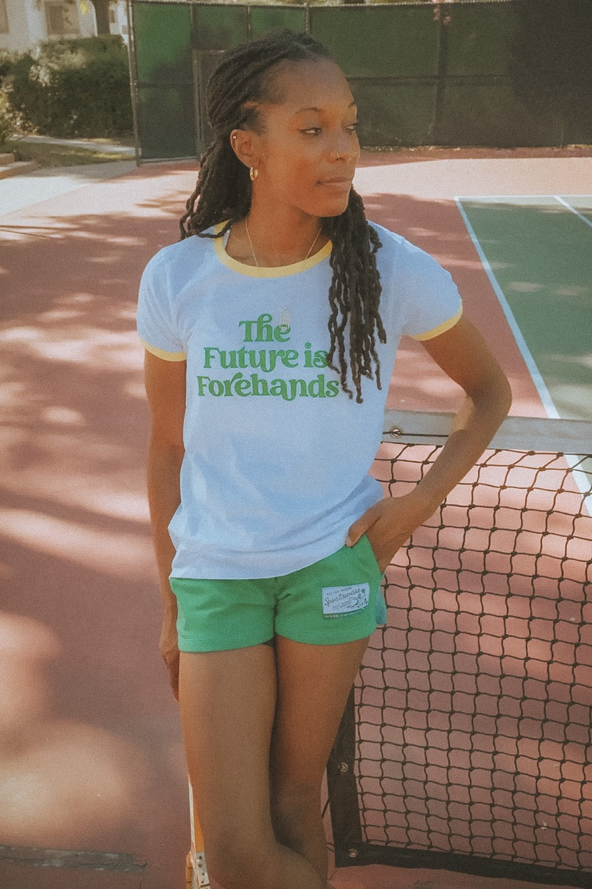 Person wearing a shirt with 'The Future is Forehands' on a tennis court