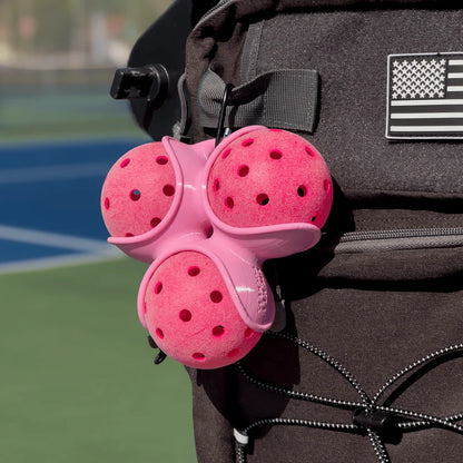 Picklepocket in Pink sports ball holder attached to a backpack on a tennis court