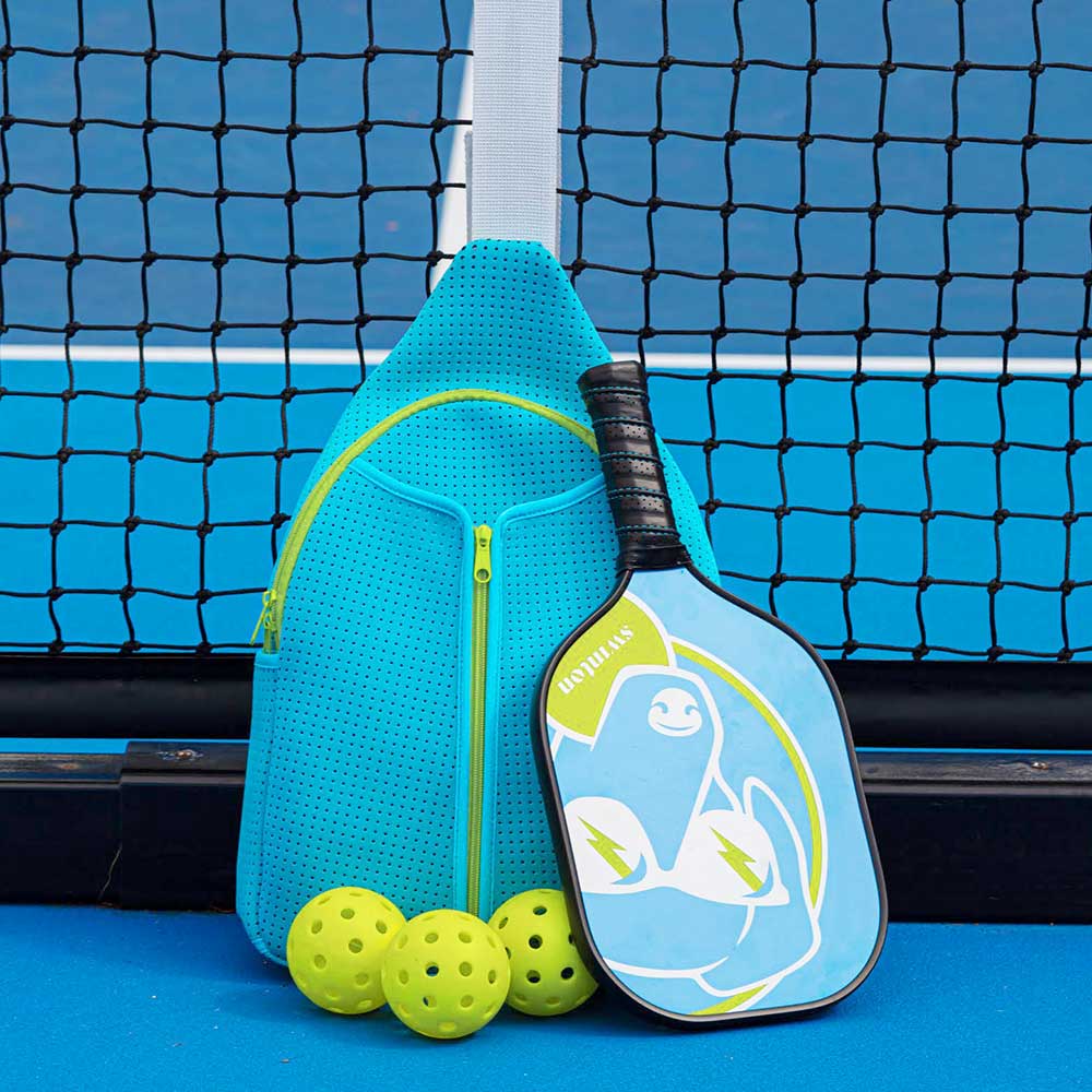 Blue paddle with green accents and pickleballs on a blue court