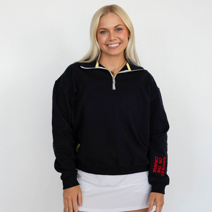Woman wearing a black quarter-zip sweatshirt with red text on sleeves against a white background