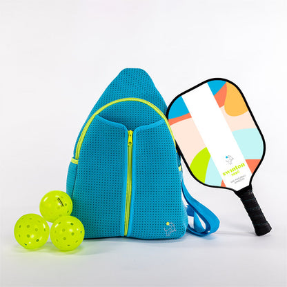 Blue pickleball bag with two pickleballs and a colorful pickleball paddle on a light gray background