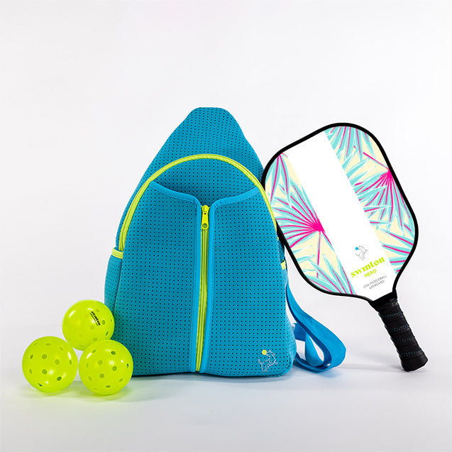 Blue pickleball bag with three green pickleballs and a colorful pickleball paddle on a white background