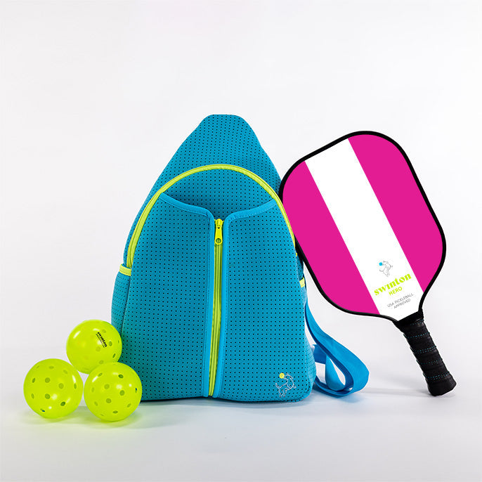 Blue pickleball bag with three yellow balls and a pink and white pickleball paddle on a light gray background