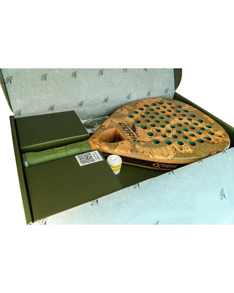 Paddle with green handle and decorative design in a box on a white background