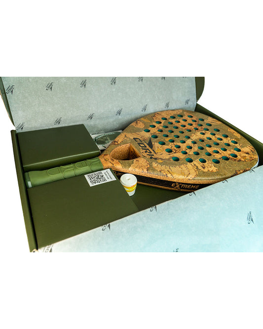 Paddle with green handle and decorative design in a box on a white background