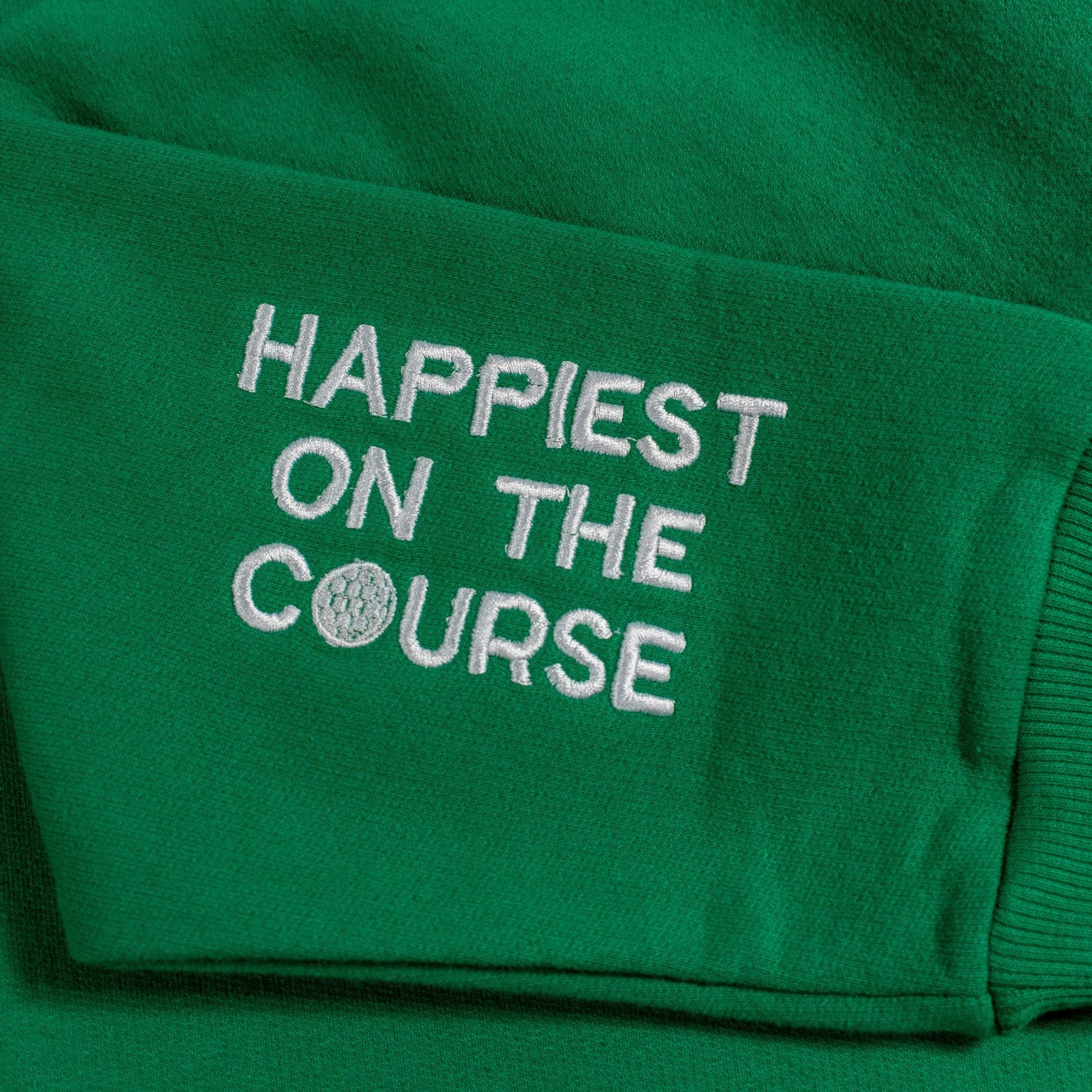 Green sweatshirt with 'Happiest on the Course' text and golf ball design.