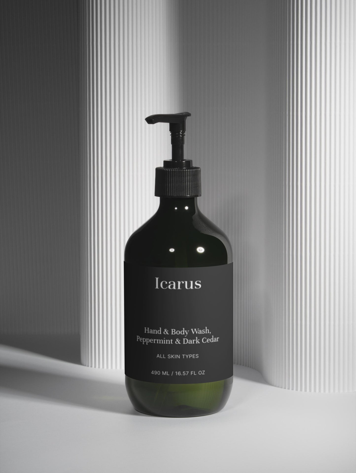 Black bottle of QEROE hand and body wash with a pump on a light gray background