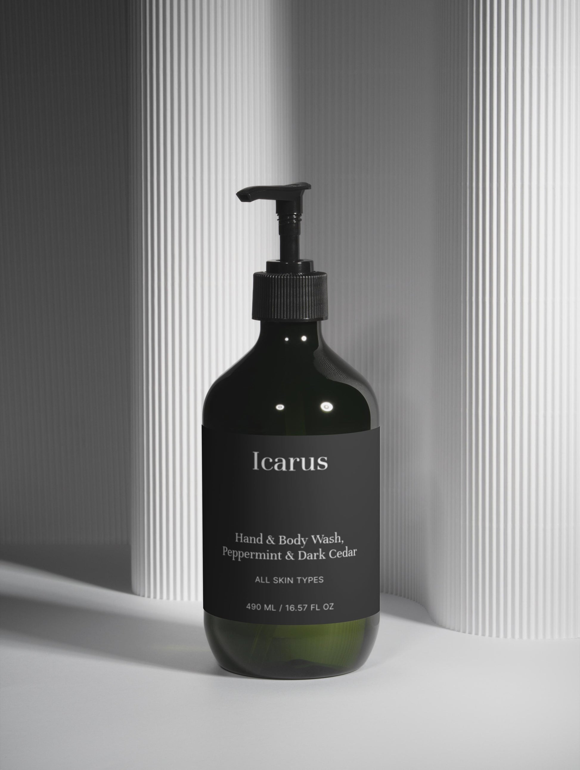 Black bottle of QEROE hand and body wash with a pump on a light gray background