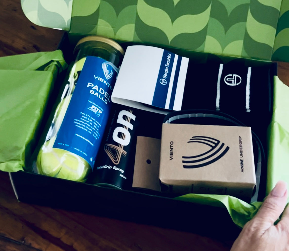 Box containing sports equipment with visible branding on a green patterned surface