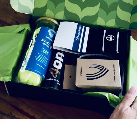 Box containing sports equipment with visible branding on a green patterned surface