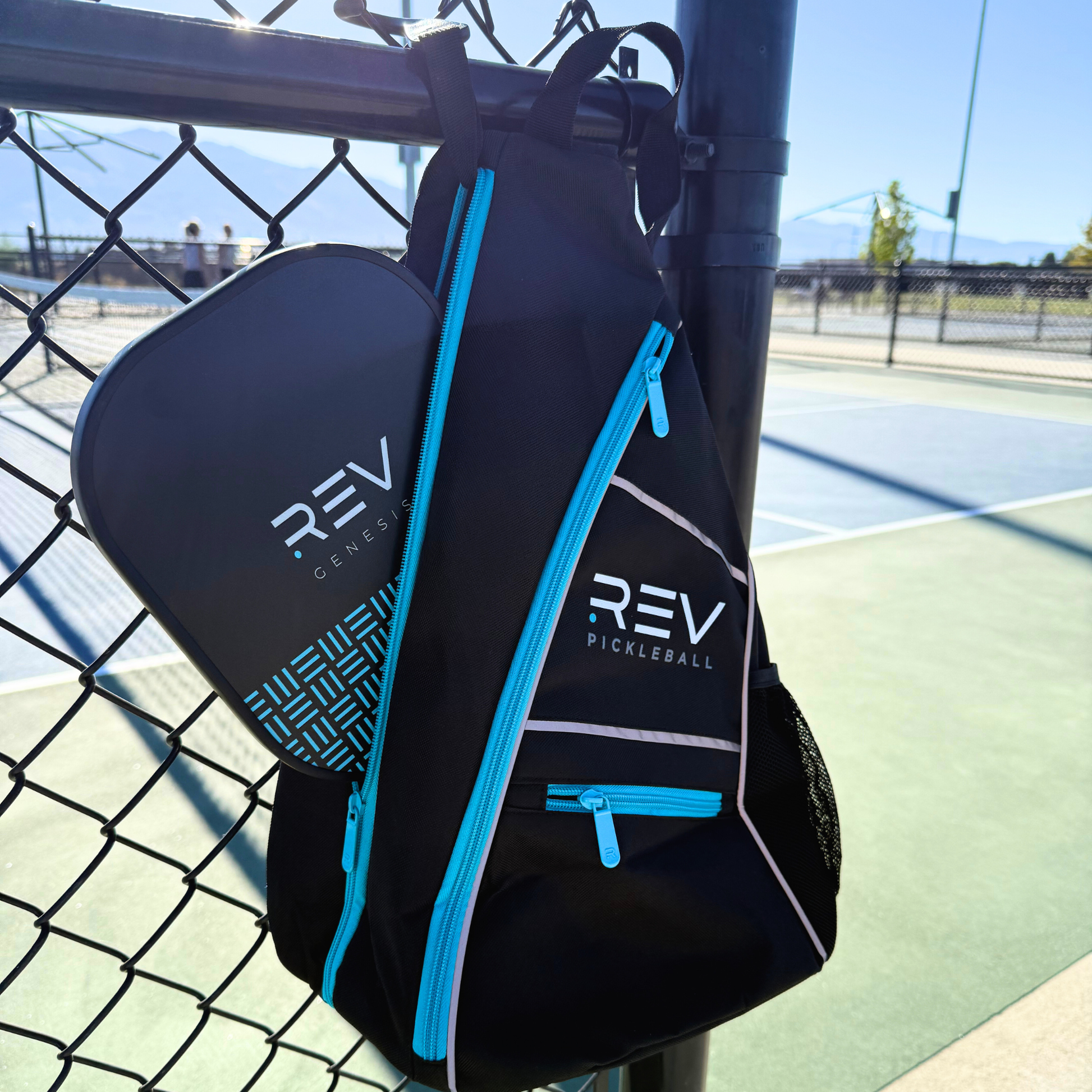 Black pickleball bag with blue accents on a pickleball court