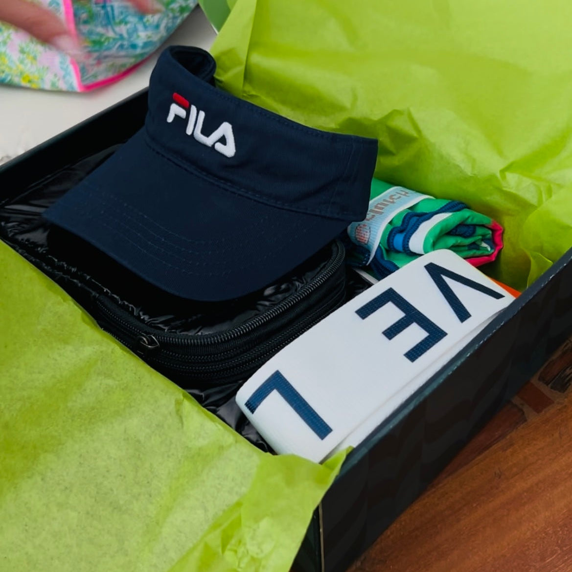 Fila visor and t-shirt in a box with green tissue paper