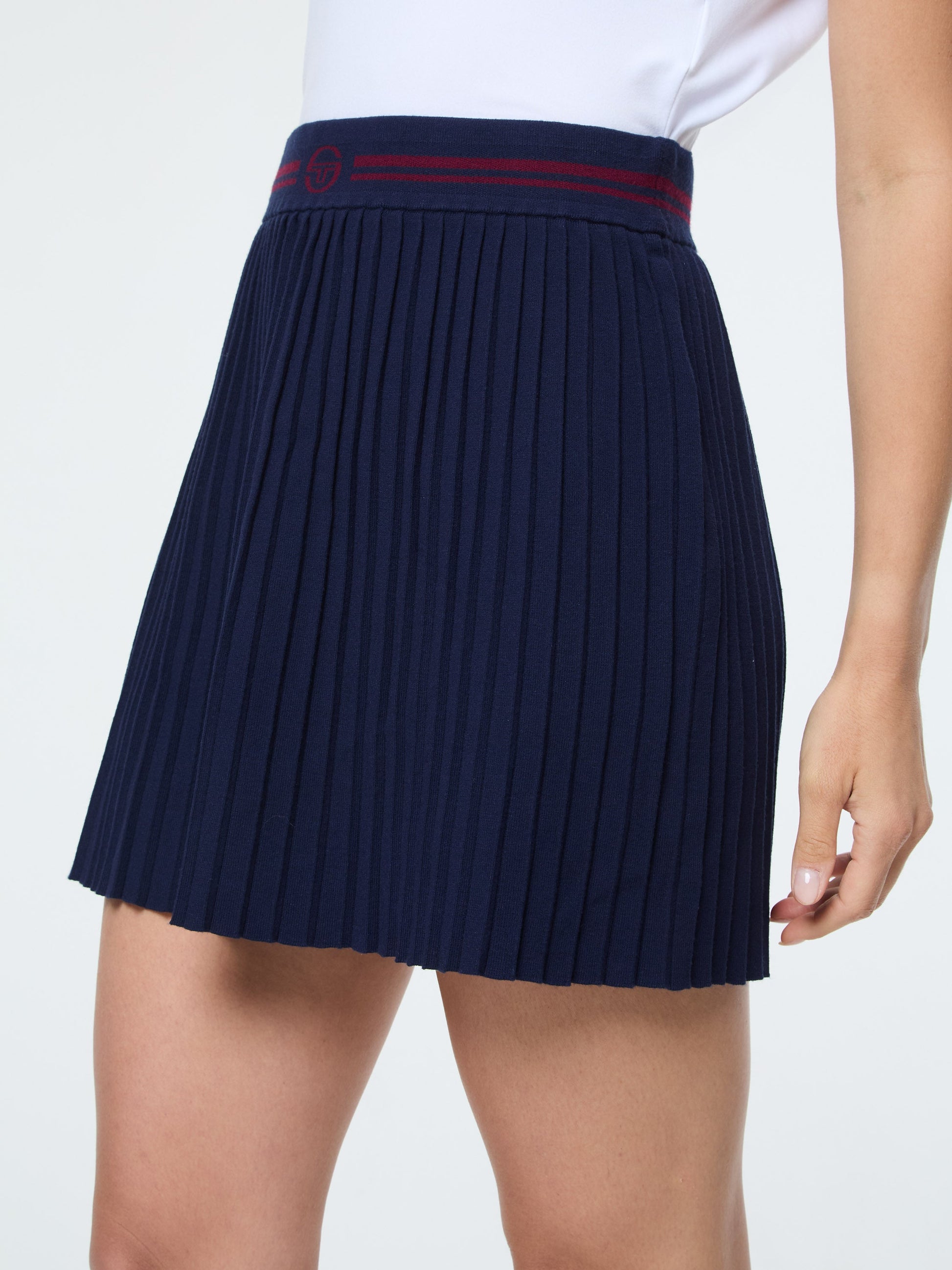 Navy pleated skirt with a red band on a white background