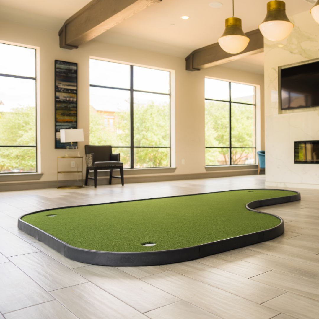 Indoor putting green in a room with large windows