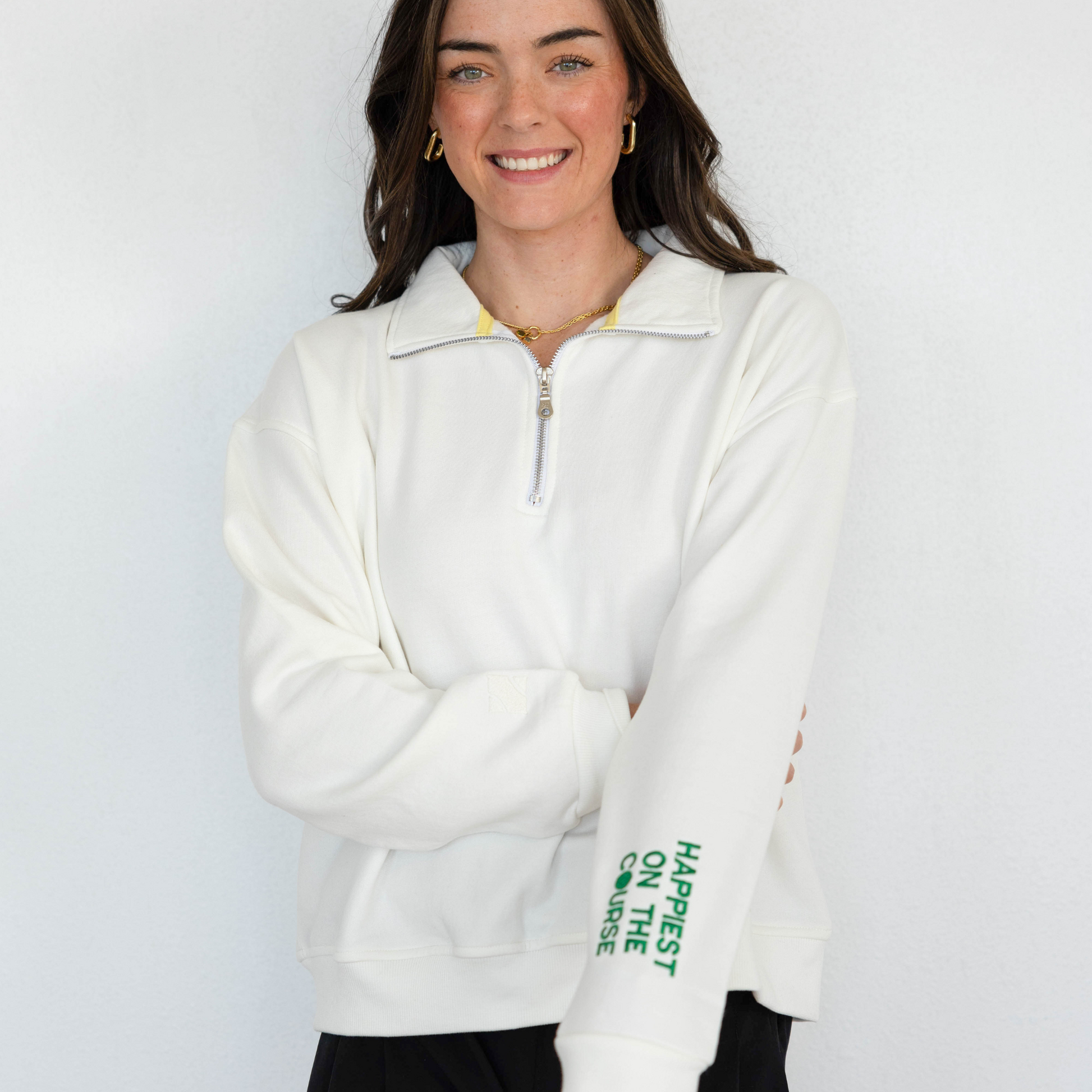 Woman wearing a white pullover with text on a plain background